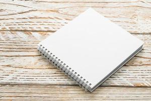 Blank notebook mock up on wooden background photo