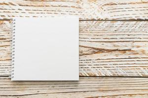 Blank notebook mock up on wooden background photo