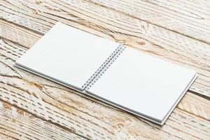 Blank notebook mock up on wooden background photo