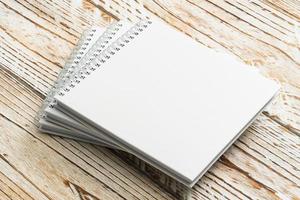 Blank notebook mock up on wooden background photo