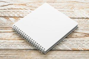 Blank notebook mock up on wooden background photo