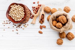 Assorted legumes and nuts on a shabby white background photo