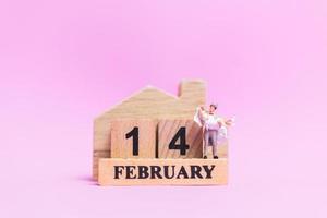 Miniature wedding of a bride and groom couple on a pink background, Valentine's Day concept photo