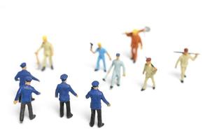 Miniature police and an angry mob on a white background photo