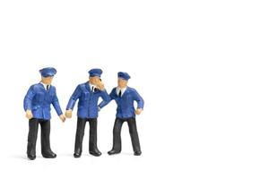Miniature policemen standing on a white background photo