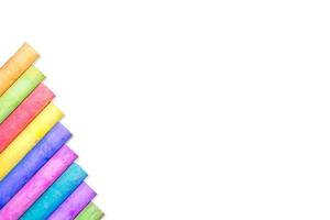 Rows of rainbow-colored chalk isolate on white background photo