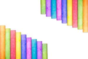 Rows of rainbow-colored chalk isolate on white background photo