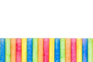 Rows of rainbow-colored chalk isolated on a white background photo