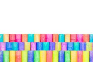 Rows of rainbow-colored chalk isolated on a white background photo