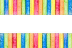Rows of rainbow-colored chalk isolated on a white background photo