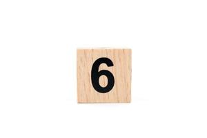 Bloque de madera número seis sobre un fondo blanco.