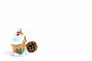 Christmas scene of Santa Claus figurine sitting on a roof on a white background photo