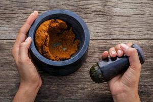 Close-up of hands grinding a spice paste photo