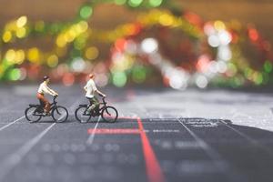 viajeros en miniatura montando una bicicleta en un mapa del mundo, viajando y explorando el concepto del mundo foto