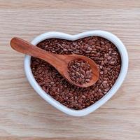 Heart-shaped bowl of flax seeds photo