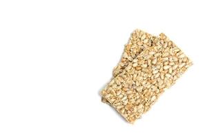 Sunflower kernels and sesame bars isolated on a white background photo