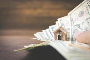 Modelo de dinero y casa sobre un fondo de madera, concepto de finanzas y banca