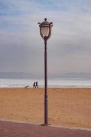 Paisaje con farola en una playa con un nublado cielo azul en Vladivostok, Rusia foto