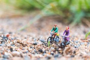 Viajeros en miniatura en bicicleta, explorando el concepto del mundo. foto