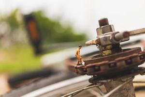 Miniature mechanics repairing a bicycle, workshop concept photo