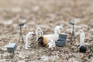 Miniature police and detectives finding proof from old cigarettes at a crime scene photo