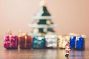 Santa Claus en miniatura con una bolsa, concepto de celebración de Navidad foto