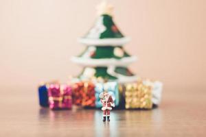 Santa Claus en miniatura con una bolsa, concepto de celebración de Navidad foto