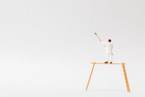 Miniature painter holding a brush on a white background photo