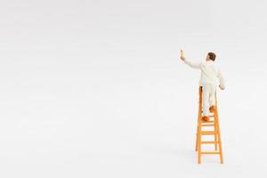 Miniature painter holding a brush on a white background photo