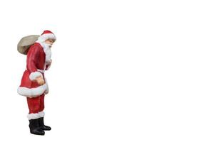 Miniature Santa Claus carrying a bag isolated on a white background photo