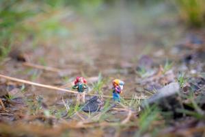 Miniature traveler with backpacks walking in the field, travel and adventure concept photo