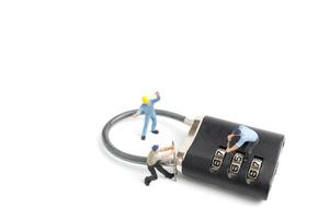 Miniature workers unlocking the password on a lock, teamwork concept photo