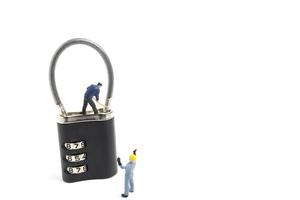 Miniature workers unlocking the password on a lock, teamwork concept photo