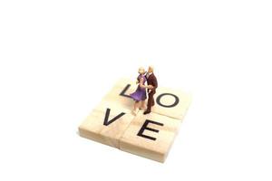 Pareja en miniatura bailando románticamente sobre un fondo blanco, concepto de día de San Valentín foto