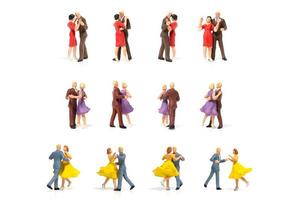 Parejas en miniatura bailando románticamente sobre un fondo blanco, el concepto de San Valentín foto