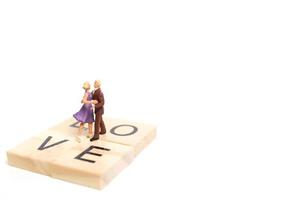 Miniature couple dancing romantically on a white background, Valentine's Day concept photo