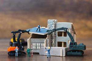 Trabajadores en miniatura construyendo un hogar, concepto de renovación del hogar foto