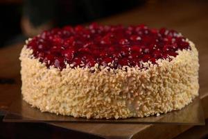 Raspberry cake with nuts on wooden table photo
