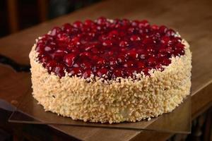 Raspberry cake with nuts on wooden table photo