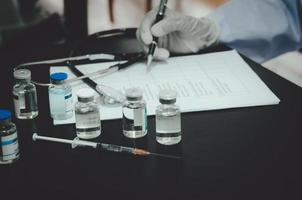 Medical professional going through checklist with vaccines on a table photo