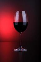 copa de vino llena de fondo rojo y negro foto