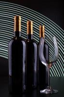 Botellas de vino y vidrio con fondo de líneas blancas foto