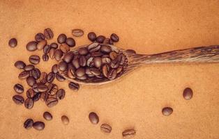 granos de café en una cuchara de madera foto