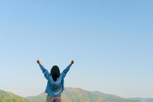 Woman with raised hands up to the sky photo