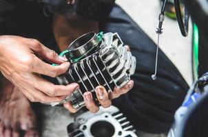 persona sosteniendo una pieza de motocicleta foto