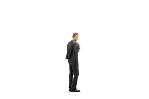 Miniature businessman standing isolated on a white background photo