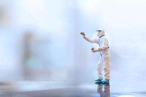 Miniature doctor wearing a facemask during coronavirus and flu outbreak, virus and illness protection concept photo