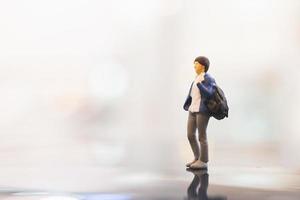 Miniature traveler with a backpack walking on empty space, travel concept photo