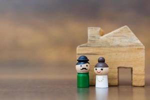 Miniature wooden dolls with happy faces on a wooden background photo