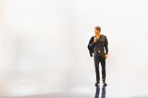 Miniature businessman standing on empty space photo